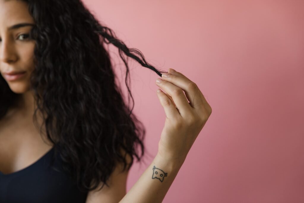 Eenjongere vrouw die speelt met haar golvende haren